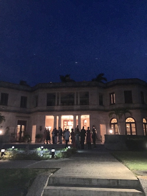 People mingling outside of the U.S. Residence in the evening